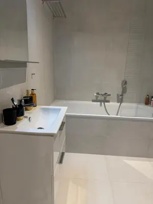 a white bathroom with a tub and a sink at The Shalom in Prague