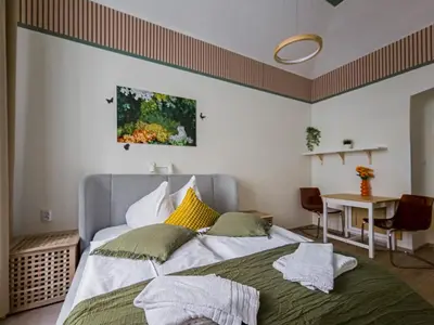a bedroom with a large bed and a table at Heart of Zizkov in Prague