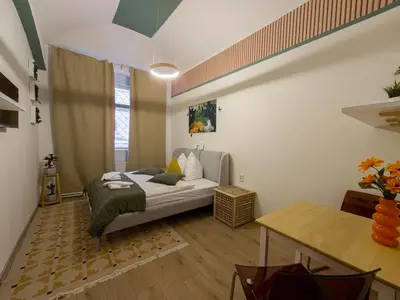 a small bedroom with a bed and a table at Heart of Zizkov in Prague