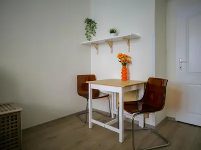 a table with two chairs and a vase with flowers on it at Heart of Zizkov in Prague