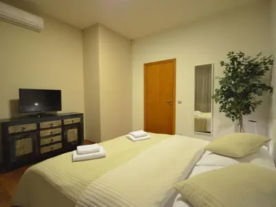 a bedroom with two beds with white sheets and a television at Apartment mit Terrasse by Interhome in Prague