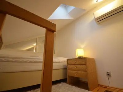 a bedroom with a bed and a lamp on a dresser at Apartment Wohnung Attic Josefov mit eigener Terrasse by Interhome in Prague