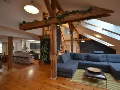 a living room with a blue couch and a kitchen at Apartment Wohnung Attic Josefov mit eigener Terrasse by Interhome in Prague