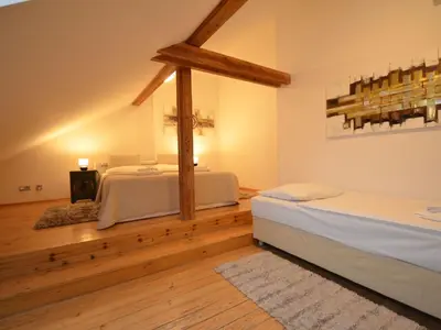 two beds in a room with wooden floors at Apartment Wohnung Attic Josefov mit eigener Terrasse by Interhome in Prague