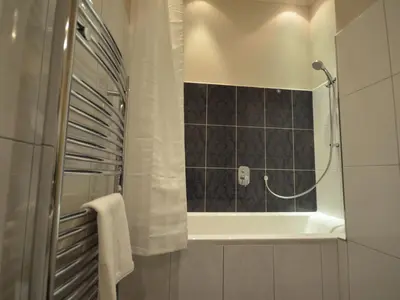 a bathroom with a tub and a shower with a mirror at Apartment Wohnung mit eigenem Balkon by Interhome in Prague
