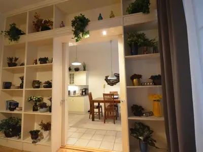 a room with shelves with potted plants and a dining room at Apartment Collection Hastalska by Interhome in Prague