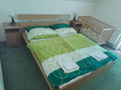 a bed with green and white sheets and pillows at Holiday Home Komfortvilla in Prag- Hallenbad- Whirlpool- Sauna by Interhome in Vranov