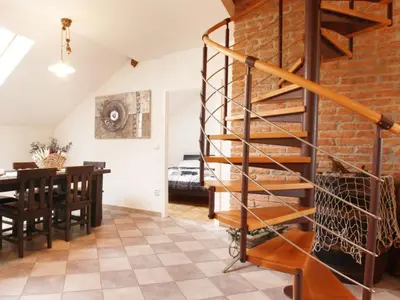 a spiral staircase in a dining room with a dining table at Apartment Apartment mit Waschmaschine und Geschirrspüler by Interhome in Prague