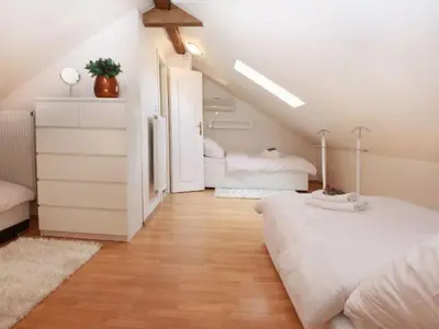 a attic bedroom with two beds and a staircase at Apartment Apartment mit Waschmaschine und Geschirrspüler by Interhome in Prague