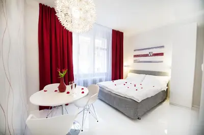 a bedroom with a bed and a white table and chairs at Honeymoon Ruterra studio in Prague