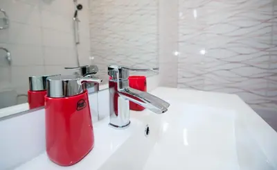 a bathroom with a sink with two faucets on it at Honeymoon Ruterra studio in Prague