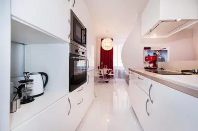 a white kitchen with white cabinets and a microwave at Honeymoon Ruterra studio in Prague