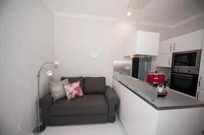 a small living room with a couch in a kitchen at Honeymoon Ruterra studio in Prague