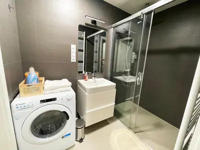 a washing machine in a bathroom with a shower at Modern Žižkov apartment in the center in Prague
