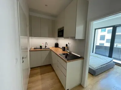 a kitchen with white cabinets and a sink and a window at Modern Žižkov apartment in the center in Prague