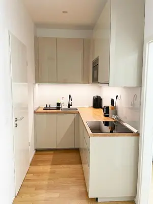 a kitchen with white cabinets and a sink at Modern Žižkov apartment in the center in Prague