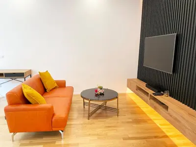 a living room with an orange couch and a tv at Modern Žižkov apartment in the center in Prague