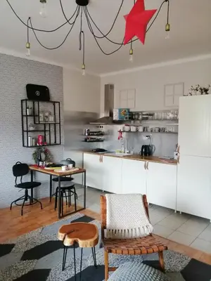 a kitchen with a table and a red star on the ceiling at ANDĚL apartment VLTAVA' SPIRIT - Smíchov in Prague