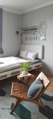 a bedroom with a bed and a table with a couch at ANDĚL apartment VLTAVA' SPIRIT - Smíchov in Prague