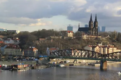a bridge over a river with a city in the background at ANDĚL apartment VLTAVA' SPIRIT - Smíchov in Prague