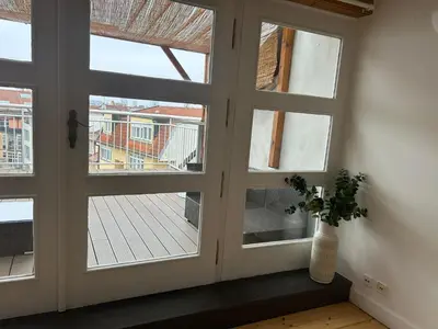 a room with three windows and a vase with a plant at Náměstí Míru 13 in Prague