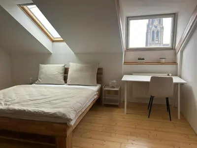 a bedroom with a bed and a desk and a window at Náměstí Míru 13 in Prague