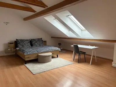 a bedroom with a bed and a desk with skylights at Náměstí Míru 13 in Prague