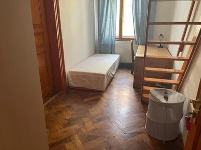 a small room with a bed and a wooden floor at Central cozy rooms Soukenická S32 in Prague