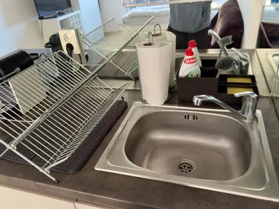 a kitchen sink with a dish drying rack on a counter at Smart Studio for Work & City Exploring in Prague
