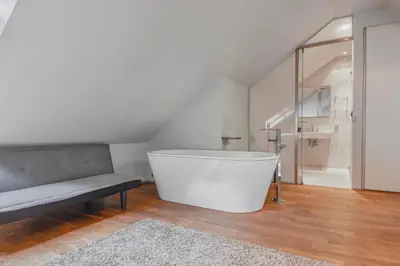 a white bath tub in a room with a bench at Luxury Apartment in Centre in Prague