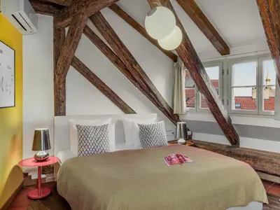 a bedroom with a large bed in a room with wooden ceilings at Three Bedroom Apartment with terrace Kepler-4 Art in Prague