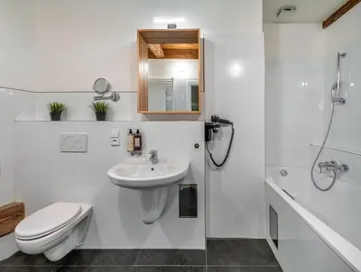a white bathroom with a toilet and a sink at Three Bedroom Apartment with terrace Kepler-4 Art in Prague