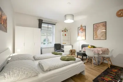 a bedroom with three beds and a table and a desk at Lovely Prague Apartment 2 in Prague