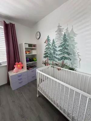 a nursery with a crib and christmas trees on the wall at Villa with Terrace & private garden 30 min to Prague Center