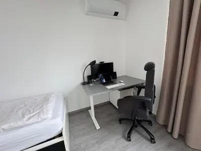 a bedroom with a desk with a computer and a bed at Villa with Terrace & private garden 30 min to Prague Center