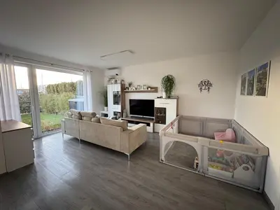 a living room with a couch and a baby crib at Villa with Terrace & private garden 30 min to Prague Center