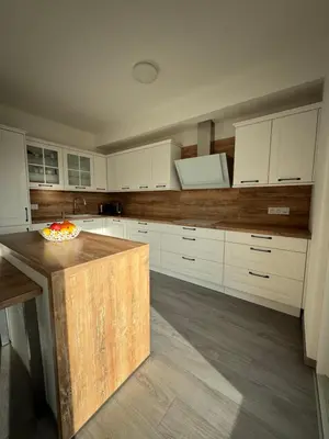 a kitchen with white cabinets and a bowl of fruit on a counter at Villa with Terrace & private garden 30 min to Prague Center