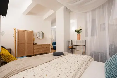 a bedroom with a large bed and a dresser at Art Apartment in Prague