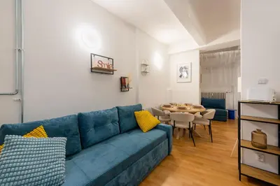 a living room with a blue couch and a table at Art Apartment in Prague