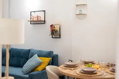 a living room with a blue couch and a table at Art Apartment in Prague
