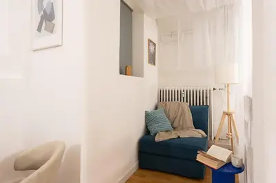 a living room with a blue couch and a lamp at Art Apartment in Prague