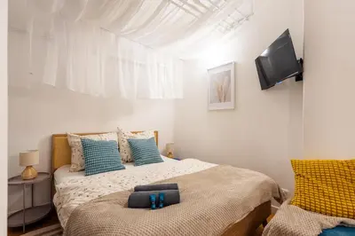 a bedroom with a bed and a flat screen tv at Art Apartment in Prague