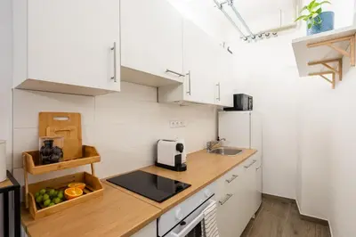 a kitchen with white cabinets and a wooden counter top at Art Apartment in Prague