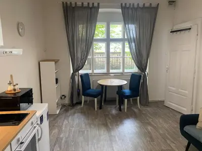 a kitchen with a table and chairs and a window at Ground Floor Den in Prague