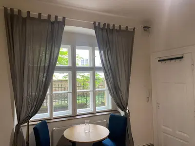 a table and chairs in a room with a window at Ground Floor Den in Prague