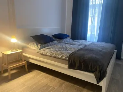 a bed with blue pillows on it in a bedroom at Ground Floor Den in Prague