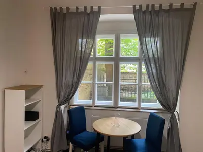 a table and chairs in front of a window at Ground Floor Den in Prague