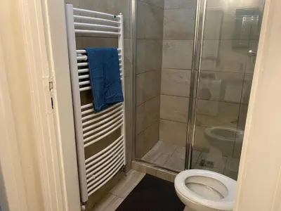 a bathroom with a toilet and a glass shower at Ground Floor Den in Prague