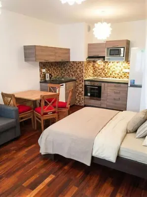 a bedroom with a bed and a table and a kitchen at Fortuna Garden II in Prague