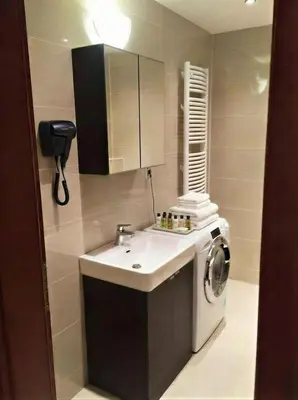 a bathroom with a sink and a washing machine at Fortuna Garden II in Prague